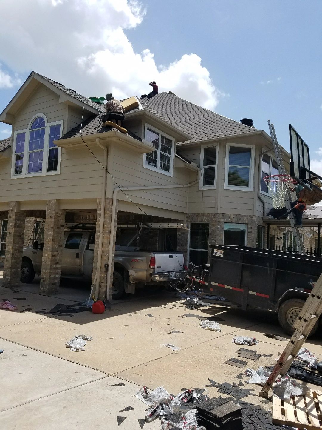 Two-story house undergoing roofing work